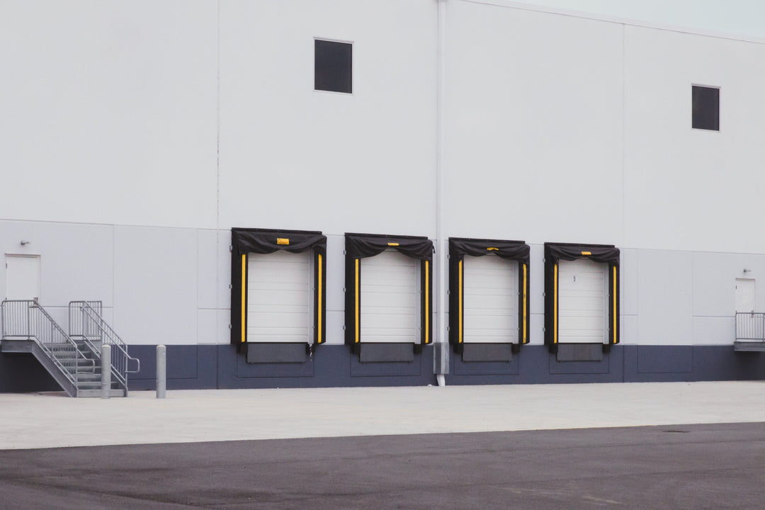 Warehouse exterior with large doors and a white wall